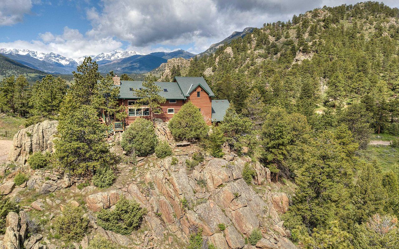 A log lodge perched on a private ridge in Estes Park with the Rocky Mountains in the distance