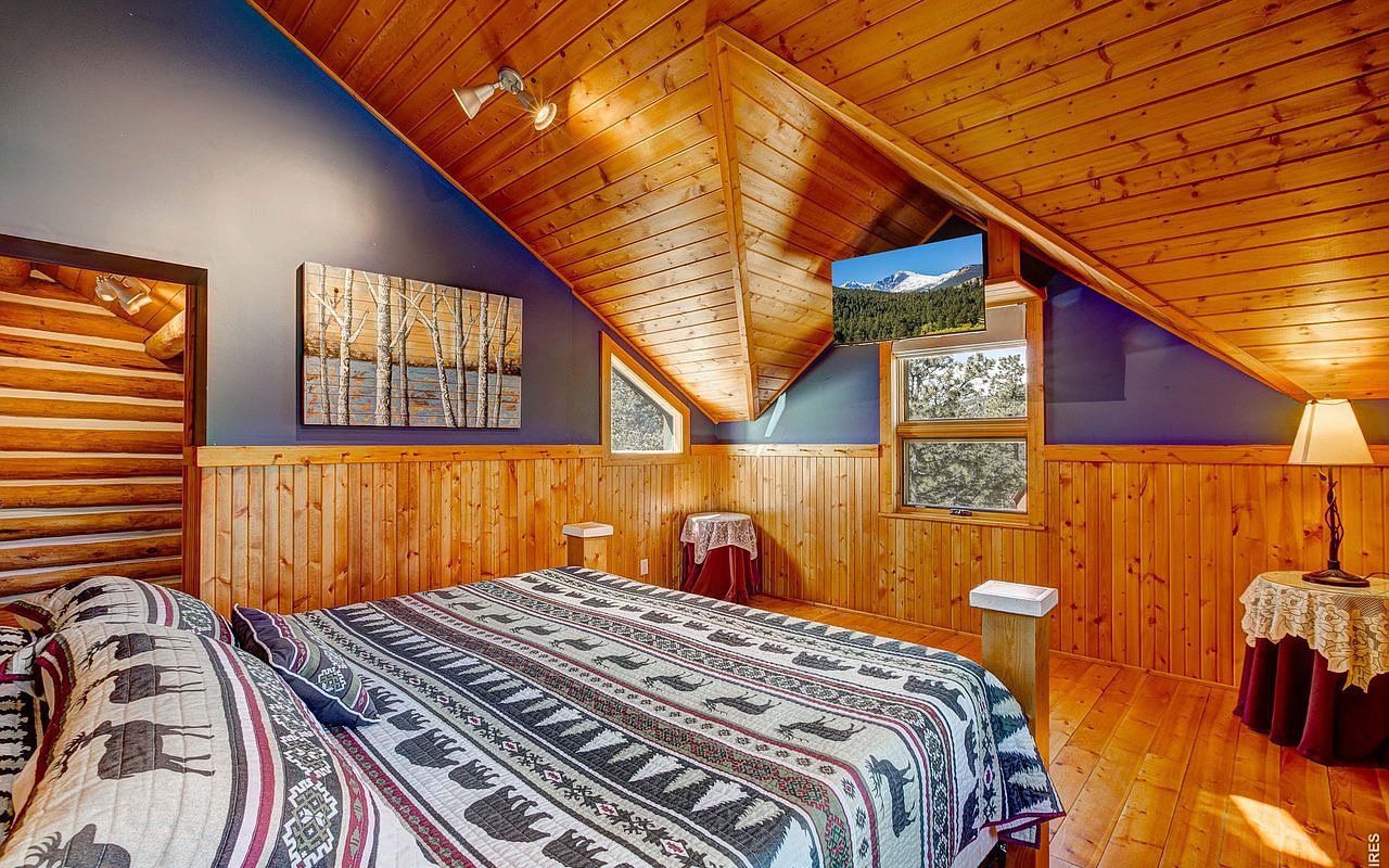 The primary bedroom — vaulted ceilings and a small mountain-view window